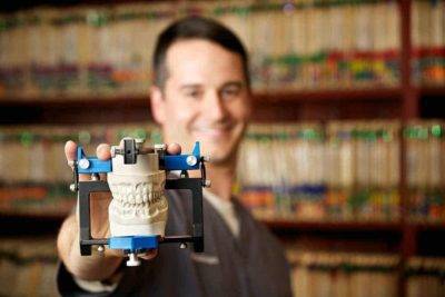 Doctor holding 3D-printed model of mouth at North County Cosmetic and Implant Dentistry in Vista, CA